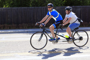 Two people riding on a tandem bike.