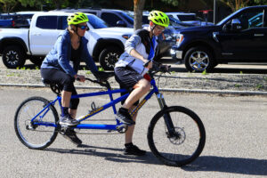 Two people on a tandem bike getting ready to ride.